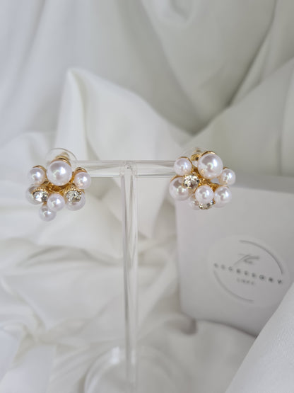 The lyla Pearl cluster gold earrings with diamond on a display t 